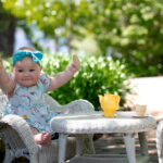 Baby girl sitting at mini tea party setup in the Friendship Garden