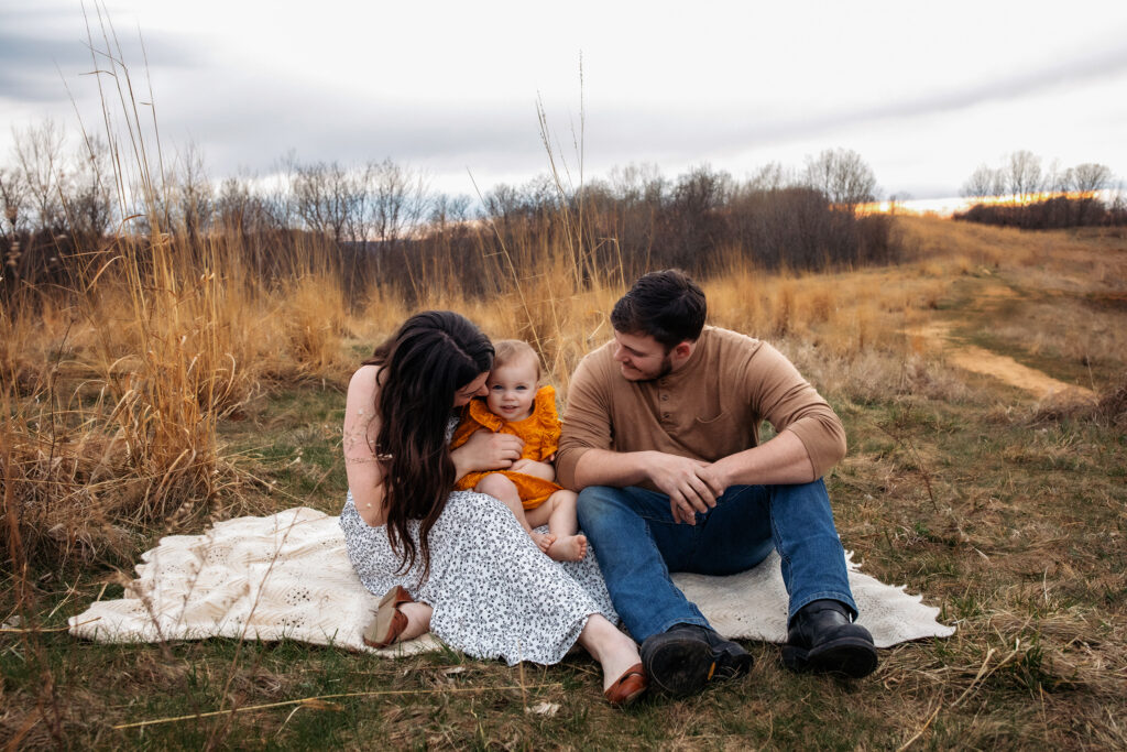 Family photography session outdoors in Holmen, Wisconsin with parents and children near a scenic bluff.
